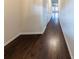 Long hallway with dark wood floors and white trim, leading to other rooms at 3375 Highbury Way, Lithonia, GA 30038