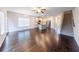 Open-concept living space with hardwood floors, flowing into the kitchen with island and stairs at 3375 Highbury Way, Lithonia, GA 30038