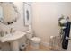 Elegant powder room features a pedestal sink, decorative mirror, and stylish floral arrangement at 4054 Lyon Blvd, Atlanta, GA 30331