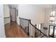 Upstairs hallway with hardwood floors leads to the foyer with a large chandelier at 4054 Lyon Blvd, Atlanta, GA 30331