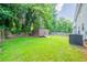 A backyard with wooden shed, green grass and an AC unit near the home at 4815 Price St, Forest Park, GA 30297