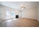Bright living room with a fireplace, ceiling fan, new floors, and a door leading to the backyard at 4815 Price St, Forest Park, GA 30297