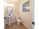 Modern powder room with pedestal sink, toilet, and vinyl flooring at 4815 Price St, Forest Park, GA 30297