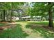 Sprawling front yard with a cozy home in the background surrounded by mature trees at 180 Kim Trail Trl, Stockbridge, GA 30281