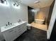 Bathroom featuring a dual vanity, modern fixtures, marble tile, and stand alone soaking tub at 1134 Donnelly Sw Ave, Atlanta, GA 30310