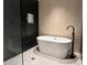 Modern bathroom featuring a soaking tub, shower with rain shower head, and unique tile design at 1134 Donnelly Sw Ave, Atlanta, GA 30310