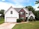 Charming two-story home featuring a brick facade, white siding, and well-manicured landscaping at 148 Barrington Pkwy, Stockbridge, GA 30281
