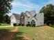 A charming home boasts a lush lawn and a classic architectural design that is both inviting and stylish at 148 Barrington Pkwy, Stockbridge, GA 30281