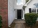 A black front door is flanked by sidelights and manicured bushes, creating a welcoming entry at 148 Barrington Pkwy, Stockbridge, GA 30281
