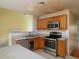 Kitchen with stainless steel appliances and an open view to the living space; needs some TLC at 148 Barrington Pkwy, Stockbridge, GA 30281