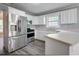 Well-lit kitchen featuring white cabinetry, modern stainless steel appliances, and wood laminate flooring at 2773 Hawk Trace Ne Ct, Marietta, GA 30066