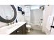 Stylish bathroom with a white vanity, modern fixtures, a round mirror, and a shower-tub combo at 420 Ashbury Cir, Dallas, GA 30157