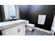 Modern bathroom featuring dark accent wall, white cabinetry, sleek fixtures, and unique gray hexagon tile floor at 420 Ashbury Cir, Dallas, GA 30157