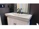 Close-up of a bathroom vanity with a white basin sink, matte black fixtures, and stylish mirror at 420 Ashbury Cir, Dallas, GA 30157