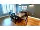 Dining room with wood floors, shutters on the windows, modern lighting, and wood table at 420 Ashbury Cir, Dallas, GA 30157
