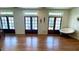 Sunlit living room featuring gleaming hardwood floors and multiple doors to the outside at 420 Ashbury Cir, Dallas, GA 30157