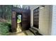 Outdoor shower featuring wooden structure and door with stone flooring and landscaping at 420 Ashbury Cir, Dallas, GA 30157