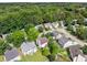 An aerial view shows a desirable neighborhood surrounded by lush greenery at 5035 Foxberry Ln, Roswell, GA 30075