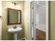Bathroom features pedestal sink, framed mirror, and paneled door at 5035 Foxberry Ln, Roswell, GA 30075