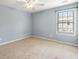 Bedroom features natural light, carpet, and a ceiling fan at 5035 Foxberry Ln, Roswell, GA 30075