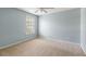Empty bedroom with a large window, neutral carpeting, and blue walls at 5035 Foxberry Ln, Roswell, GA 30075