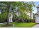 Side view of a well-maintained home featuring a lush green lawn and mature trees, providing a serene setting at 5035 Foxberry Ln, Roswell, GA 30075