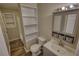 Well-lit bathroom with a combination of open shelves and a mirrored cabinet for ample storage at 11 Grove Ln, Hampton, GA 30228