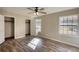 Bright bedroom features hardwood floors, a ceiling fan and natural light from a window at 11 Grove Ln, Hampton, GA 30228