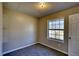 Neutral bedroom featuring carpet, a white door, and a large window at 11 Grove Ln, Hampton, GA 30228