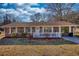 Traditional brick ranch-style house featuring bright windows, a white picket fence, and a tidy front lawn at 11 Grove Ln, Hampton, GA 30228