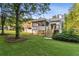 Backyard view featuring a two-story house with a deck and sunroom, complemented by a lush green lawn at 2010 Barnes Mill Rd, Marietta, GA 30062