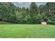 Picturesque backyard with mature trees providing privacy, and a storage shed at 2122 Browntown Rd, Rockmart, GA 30153