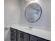 Contemporary bathroom features a round mirror, gray vanity, and pristine white countertop at 2122 Browntown Rd, Rockmart, GA 30153