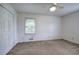 This bedroom features neutral carpeting, a window and closet providing calm, comfortable living space at 2122 Browntown Rd, Rockmart, GA 30153