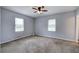 A spacious bedroom with carpeted floors, neutral walls, and two windows for natural light at 2122 Browntown Rd, Rockmart, GA 30153