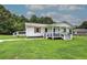 Side angle of home with covered porch, deck, stylish railings and a lush green lawn at 2122 Browntown Rd, Rockmart, GA 30153