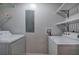 A laundry room with a side-by-side washer and dryer, wall-mounted shelves and utility connections at 2122 Browntown Rd, Rockmart, GA 30153