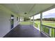 Side angle view of covered porch with black railings, stylish white supports, and spacious flooring at 2122 Browntown Rd, Rockmart, GA 30153