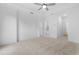 Spacious bedroom featuring neutral carpet, a tray ceiling with fan, and multiple doorways at 340 Olmstead Way # 34, Alpharetta, GA 30022