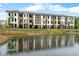 A view of modern townhomes overlooking a serene pond, blending urban living with natural beauty at 340 Olmstead Way # 34, Alpharetta, GA 30022