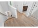 Hallway with stairs leading to the upper level, showcasing hardwood flooring and neutral decor at 340 Olmstead Way # 34, Alpharetta, GA 30022