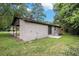 Brick home exterior with a covered patio and a spacious yard framed by mature trees for private outdoor living at 5400 Louis Xiv Ln, Atlanta, GA 30349