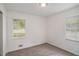 Well-lit bedroom with neutral carpet and two windows offering a bright space at 5400 Louis Xiv Ln, Atlanta, GA 30349