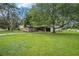 Expansive green lawn leads to a quaint brick home shaded by mature trees at 5400 Louis Xiv Ln, Atlanta, GA 30349