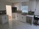 Bright kitchen featuring white cabinets, modern countertops, gray backsplash, and stylish tile flooring at 5400 Louis Xiv Ln, Atlanta, GA 30349