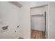 Functional laundry area with wood-look floors and access to an open closet space for efficient organization at 5400 Louis Xiv Ln, Atlanta, GA 30349