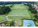 Aerial view showcases the golf course, tennis courts, and expansive community green spaces at 7216 Eton Ln, Locust Grove, GA 30248