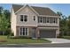 Charming two-story home with stone accents, gray siding, a two-car garage, and a well-manicured lawn at 7216 Eton Ln, Locust Grove, GA 30248
