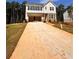 Two-story house with an attached garage and a long driveway leading to it surrounded by a landscape of trees at 7216 Eton Ln, Locust Grove, GA 30248