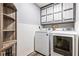 Well-lit laundry room with washer, dryer, storage, and white bead-board panelling at 1491 Stonington Ct, Villa Rica, GA 30180